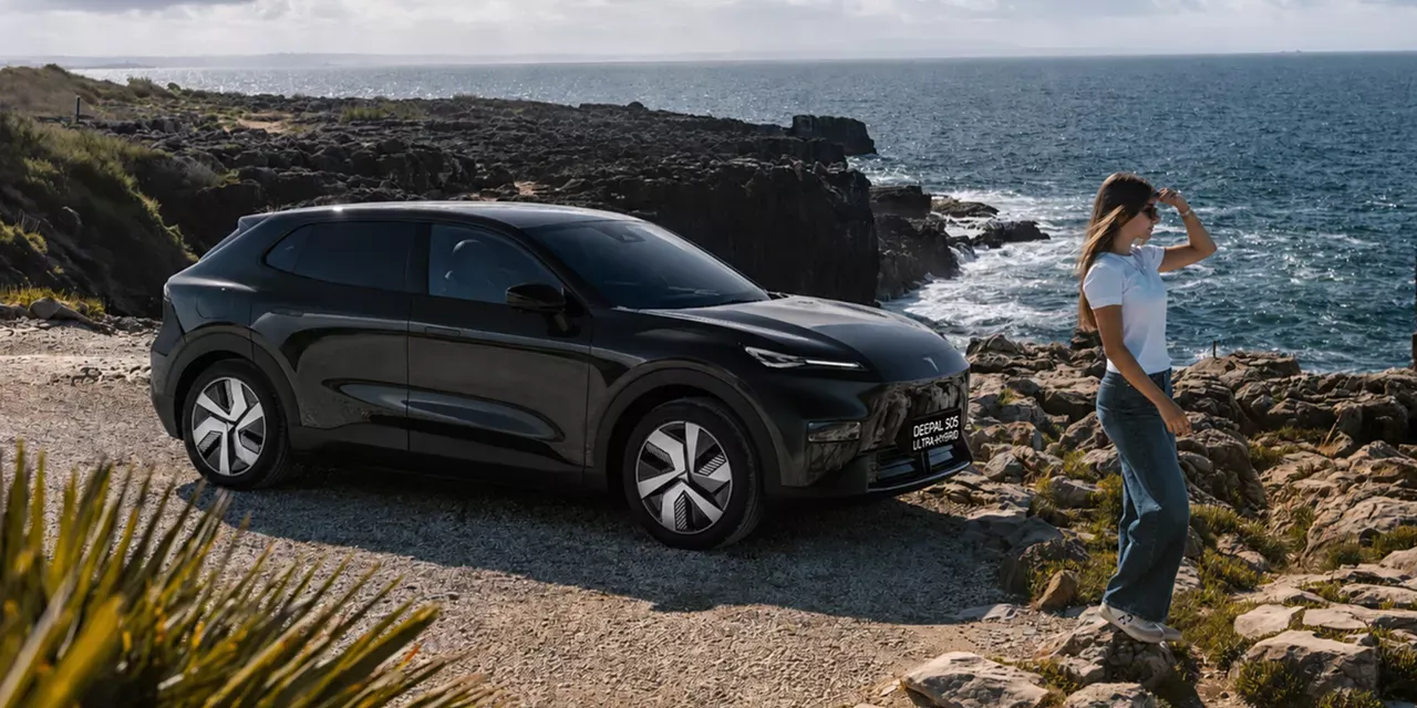 Changan Deepal S05 Ultra-Hybrid preto estacionado numa arriba costeira com uma mulher em primeiro plano a olhar para o mar